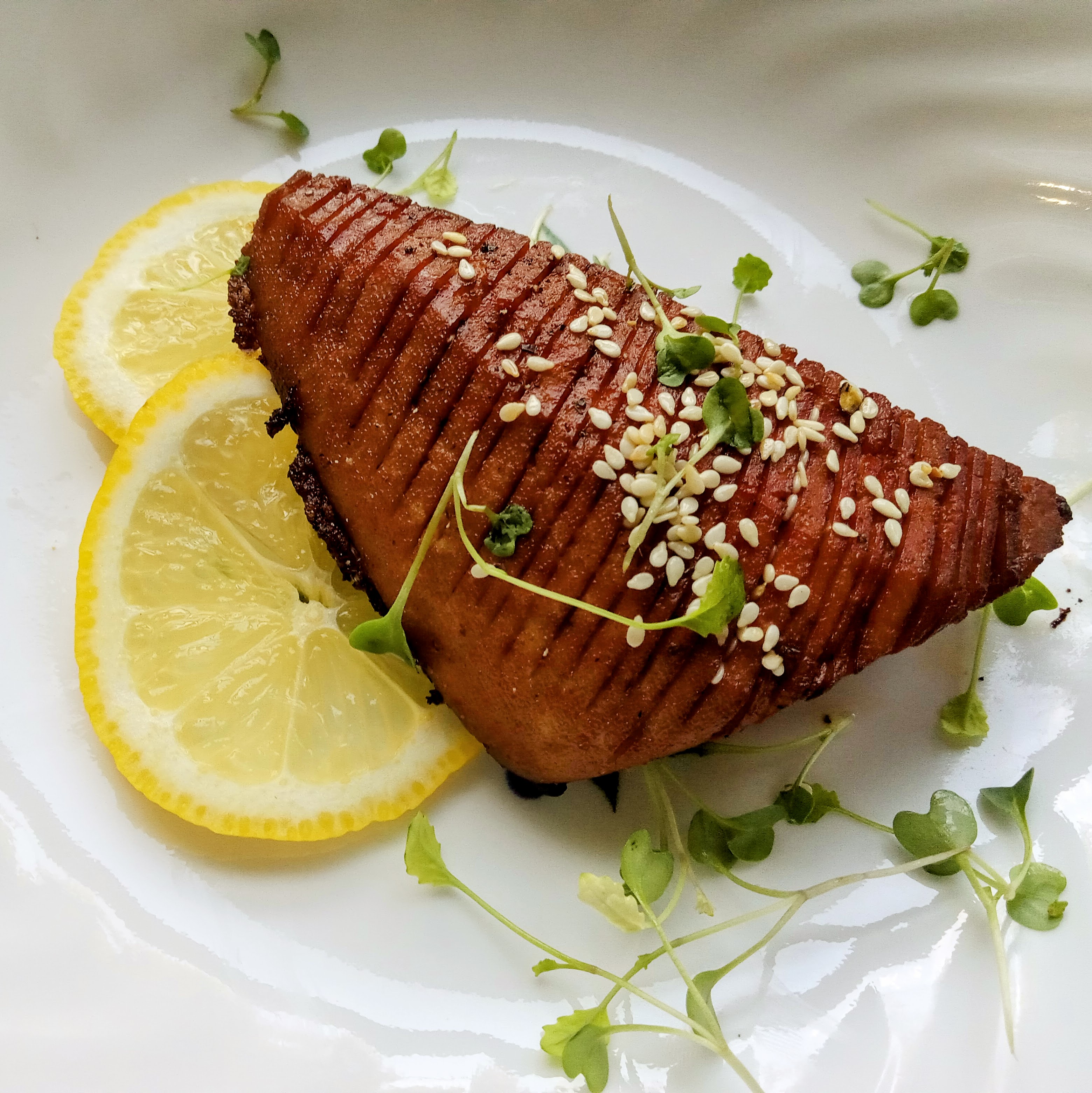 Tofu salmon filets on a plate with lemon wedges.